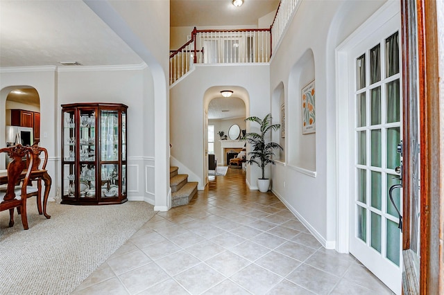 2102 Ivy Cove Ct, Katy, TX 77494 - entrance foyer featuring light tile patterned floors, arched walkways, crown molding, light carpet, and stairway
