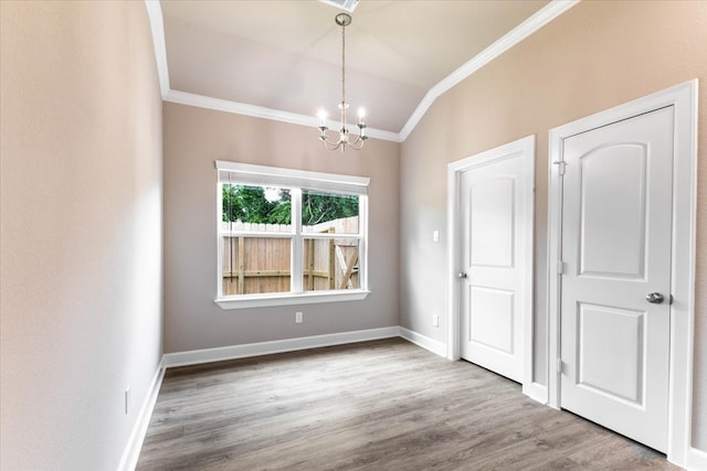 6507 Radcliffe St, Houston, TX 77091 - unfurnished dining area with crown molding, a chandelier, wood finished floors, baseboards, and vaulted ceiling
