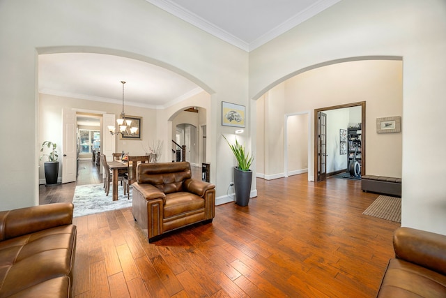 6019 Majestic Pines Dr, Houston, TX 77345 - living room with dark wood-style floors, arched walkways, a chandelier, crown molding, and baseboards