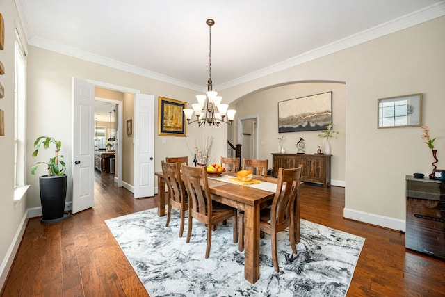 6019 Majestic Pines Dr, Houston, TX 77345 - dining area with crown molding, a chandelier, baseboards, dark wood-type flooring, and arched walkways