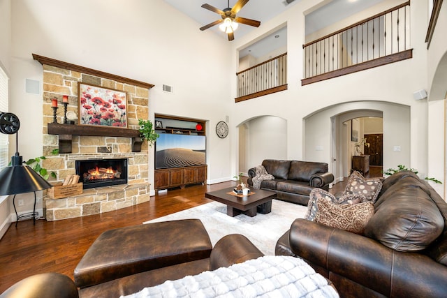 6019 Majestic Pines Dr, Houston, TX 77345 - living room with wood finished floors, a ceiling fan, a towering ceiling, baseboards, and a stone fireplace