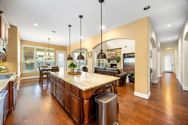 6019 Majestic Pines Dr, Houston, TX 77345 - kitchen featuring arched walkways, dark wood-style floors, baseboards, pendant lighting, and recessed lighting