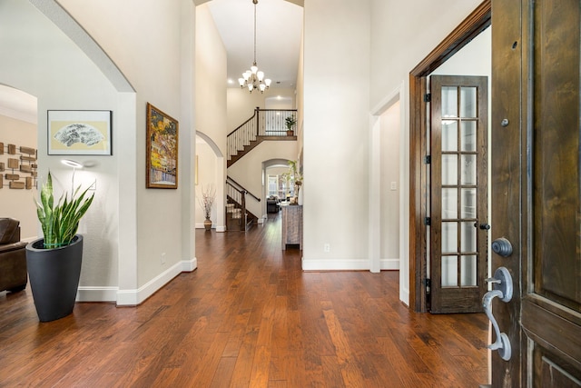 6019 Majestic Pines Dr, Houston, TX 77345 - entryway featuring arched walkways, stairs, a towering ceiling, baseboards, and wood finished floors