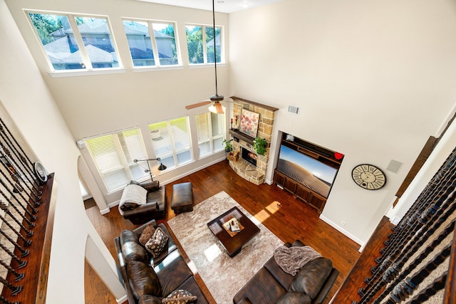 6019 Majestic Pines Dr, Houston, TX 77345 - living area featuring a high ceiling, a stone fireplace, ceiling fan, wood finished floors, and arched walkways