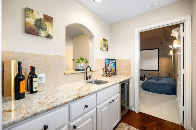 6019 Majestic Pines Dr, Houston, TX 77345 - kitchen with wine cooler, a sink, dark wood-type flooring, and light stone countertops