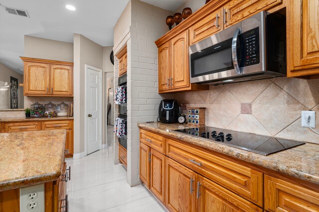 3002 Ashford Oak Dr, Houston, TX 77082 - kitchen featuring black appliances, tasteful backsplash, light stone countertops, and light tile patterned flooring