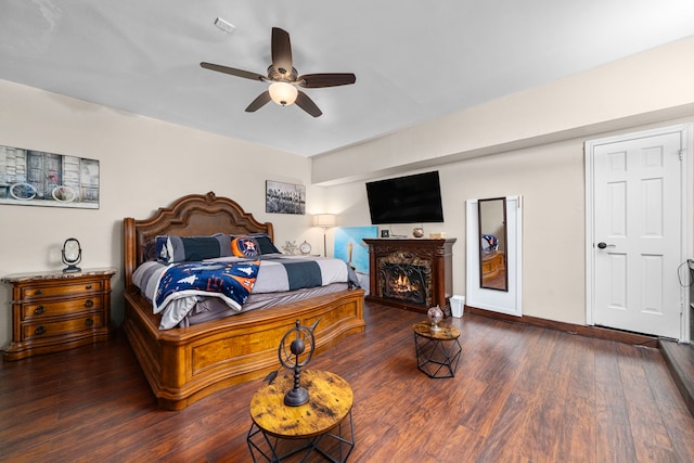 3002 Ashford Oak Dr, Houston, TX 77082 - bedroom featuring wood finished floors, ceiling fan, a lit fireplace, and baseboards