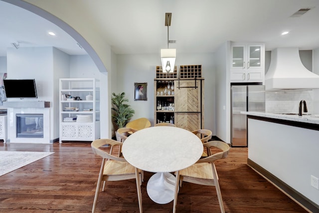1540 Lawrence St, Houston, TX 77008 - dining space featuring arched walkways, dark wood finished floors, a glass covered fireplace, baseboards, and recessed lighting