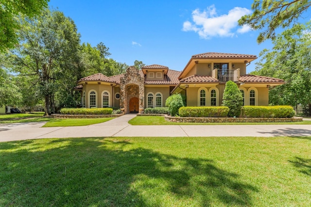 4022 Hidden Winds Dr, Spring, TX 77386 - mediterranean / spanish-style home with stucco siding, a balcony, a tiled roof, and a front yard