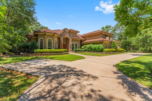 4022 Hidden Winds Dr, Spring, TX 77386 - mediterranean / spanish house featuring stucco siding, a front lawn, and a tiled roof