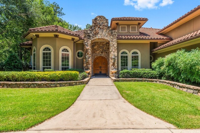 4022 Hidden Winds Dr, Spring, TX 77386 - mediterranean / spanish house with stucco siding, a front lawn, and a tiled roof