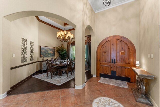 4022 Hidden Winds Dr, Spring, TX 77386 - tiled entryway with crown molding, arched walkways, a towering ceiling, a chandelier, and baseboards