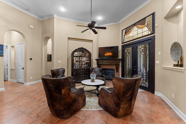 4022 Hidden Winds Dr, Spring, TX 77386 - living room featuring crown molding, a glass covered fireplace, baseboards, tile patterned flooring, and a towering ceiling
