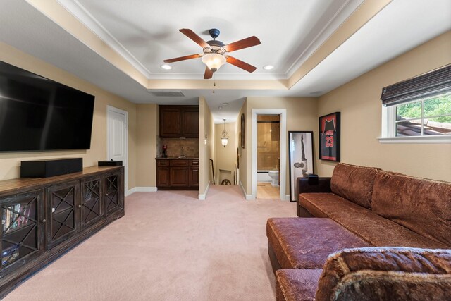4022 Hidden Winds Dr, Spring, TX 77386 - living area featuring a tray ceiling, a ceiling fan, light carpet, ornamental molding, and baseboards