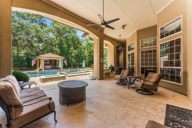 4022 Hidden Winds Dr, Spring, TX 77386 - view of patio / terrace featuring ceiling fan, an outbuilding, view of wooded area, and a pool with connected hot tub