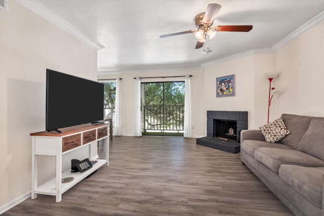3220 69th St Unit B8, Galveston, TX 77551 - living area with crown molding, wood finished floors, a ceiling fan, a fireplace, and baseboards