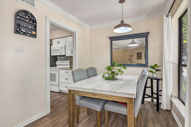 3220 69th St Unit B8, Galveston, TX 77551 - dining room featuring ornamental molding, dark wood-style flooring, and baseboards