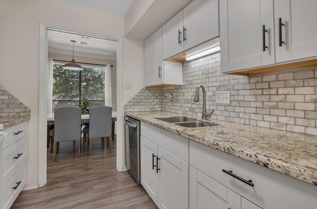 3220 69th St Unit B8, Galveston, TX 77551 - kitchen featuring a sink, stainless steel dishwasher, light wood-type flooring, white cabinetry, and tasteful backsplash