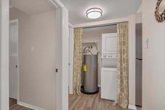 3220 69th St Unit B8, Galveston, TX 77551 - laundry room with stacked washer / dryer, water heater, wood finished floors, and baseboards