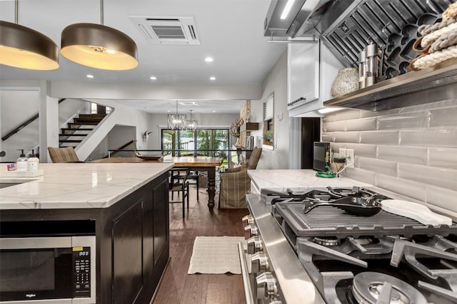 678 Sawmill St, Crockett, TX 75835 - kitchen with stainless steel appliances, dark wood-style flooring, light stone counters, a chandelier, and decorative light fixtures