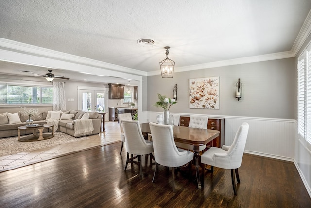 10207 Chatterton Dr, Houston, TX 77043 - dining room featuring wainscoting, wood finished floors, crown molding, ceiling fan, and a textured ceiling