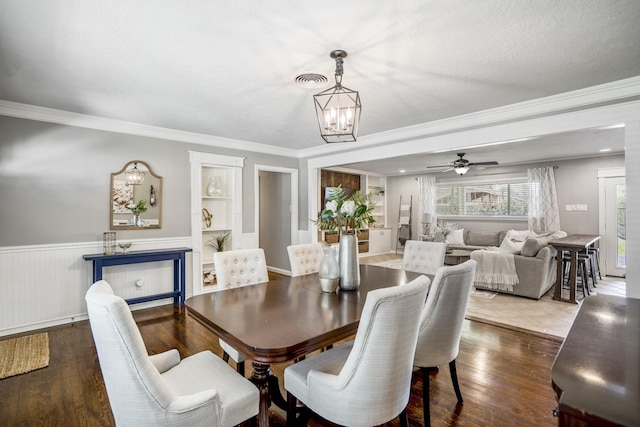 10207 Chatterton Dr, Houston, TX 77043 - dining room featuring a chandelier, a wainscoted wall, crown molding, wood finished floors, and built in shelves