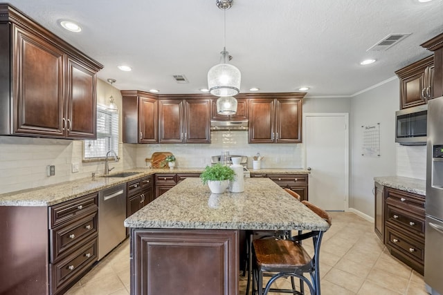 10207 Chatterton Dr, Houston, TX 77043 - kitchen featuring stainless steel appliances, a sink, decorative backsplash, a breakfast bar area, and decorative light fixtures