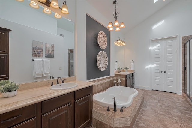 7 Edgemont Ct, Fulshear, TX 77441 - full bathroom with two vanities, a stall shower, a tub with jets, high vaulted ceiling, and a chandelier