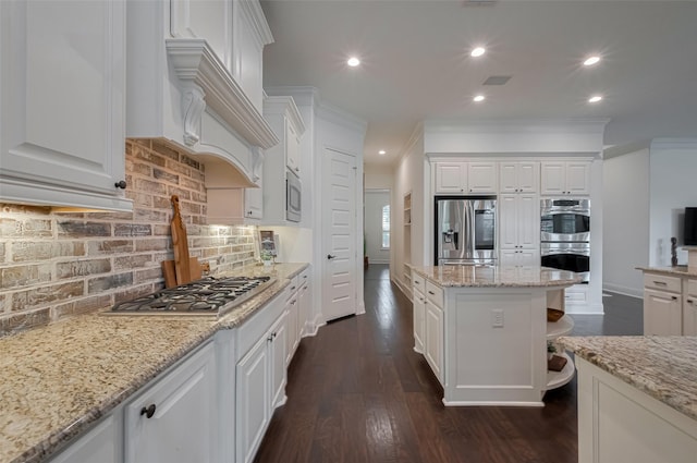 7 Edgemont Ct, Fulshear, TX 77441 - kitchen with stainless steel appliances, white cabinetry, backsplash, recessed lighting, and ornamental molding