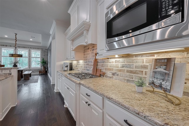 7 Edgemont Ct, Fulshear, TX 77441 - kitchen featuring appliances with stainless steel finishes, white cabinetry, dark wood-type flooring, backsplash, and baseboards