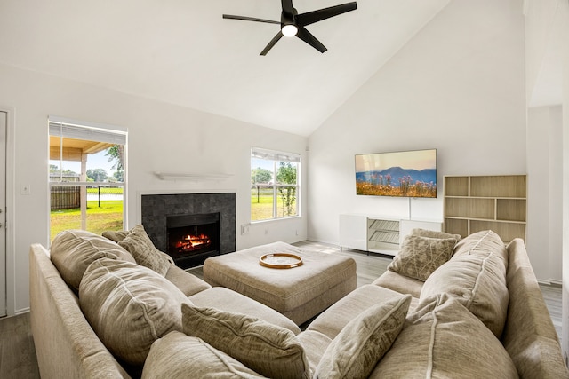 3107 Snug Harbour Ct, Katy, TX 77449 - living room with wood finished floors, ceiling fan, high vaulted ceiling, a lit fireplace, and baseboards
