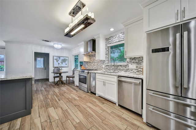 963 Thornton Rd, Houston, TX 77018 - kitchen featuring stainless steel appliances, a sink, wall chimney exhaust hood, backsplash, and white cabinets