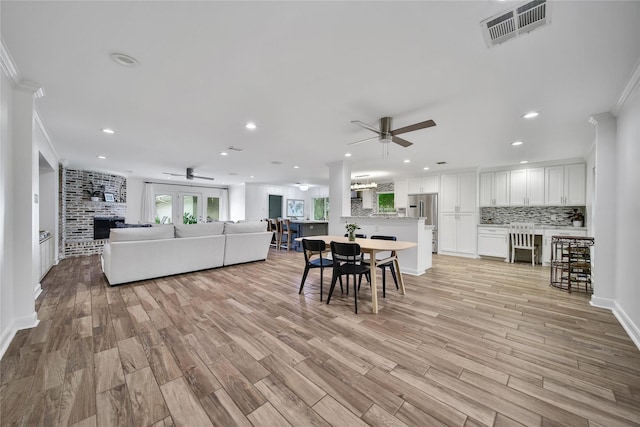 963 Thornton Rd, Houston, TX 77018 - living room with ceiling fan, a fireplace, crown molding, recessed lighting, and light wood finished floors