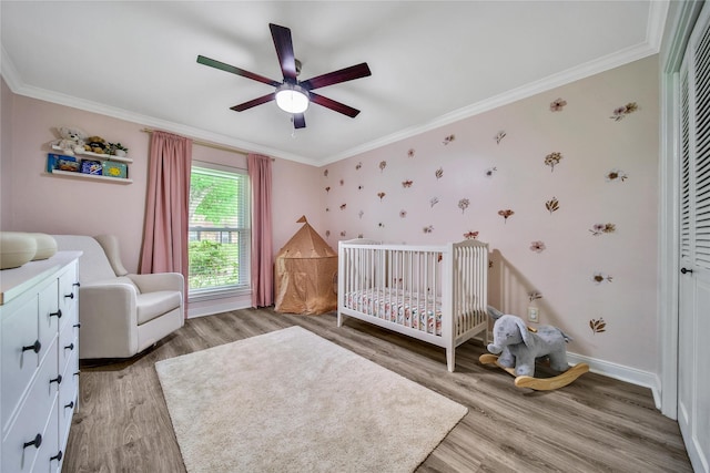 963 Thornton Rd, Houston, TX 77018 - bedroom with light wood-style flooring, a crib, ornamental molding, baseboards, and a ceiling fan