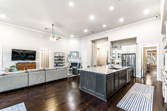 27511 Becketts Knoll Ct, Katy, TX 77494 - kitchen featuring white cabinetry, open floor plan, a sink, a kitchen island with sink, and a fireplace