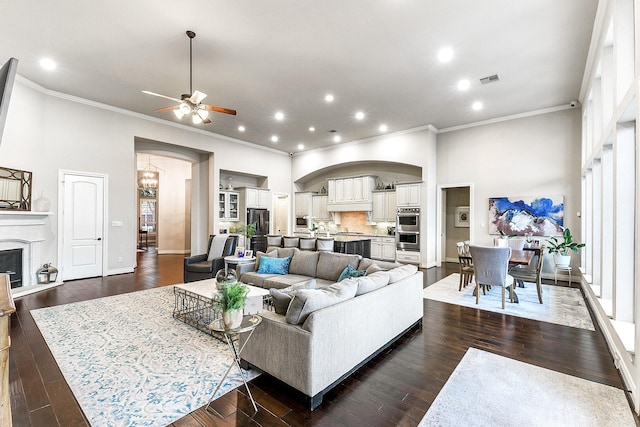 27511 Becketts Knoll Ct, Katy, TX 77494 - living room featuring ornamental molding, arched walkways, ceiling fan, dark wood-style floors, and recessed lighting