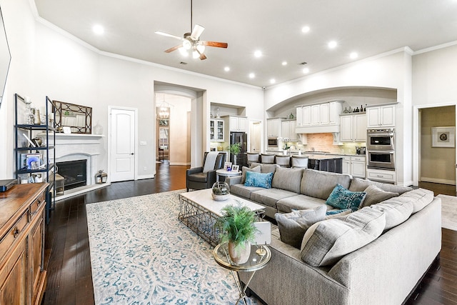 27511 Becketts Knoll Ct, Katy, TX 77494 - living room with ornamental molding, a ceiling fan, arched walkways, dark wood-style flooring, and recessed lighting
