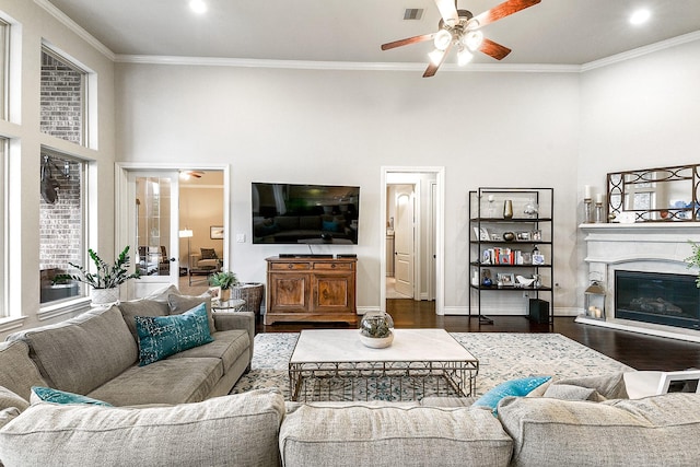 27511 Becketts Knoll Ct, Katy, TX 77494 - living room with a ceiling fan, a glass covered fireplace, ornamental molding, wood finished floors, and a high ceiling