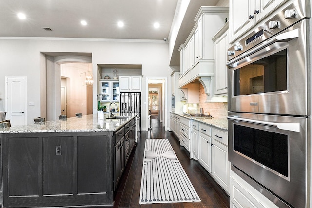 27511 Becketts Knoll Ct, Katy, TX 77494 - kitchen featuring double oven, white cabinets, a sink, dark wood-type flooring, and ornamental molding