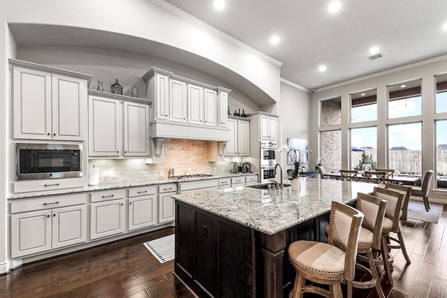 27511 Becketts Knoll Ct, Katy, TX 77494 - kitchen featuring ornamental molding, appliances with stainless steel finishes, a sink, recessed lighting, and a kitchen breakfast bar