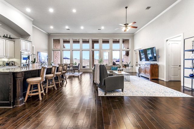 27511 Becketts Knoll Ct, Katy, TX 77494 - living area with ornamental molding, a ceiling fan, dark wood-type flooring, a towering ceiling, and recessed lighting