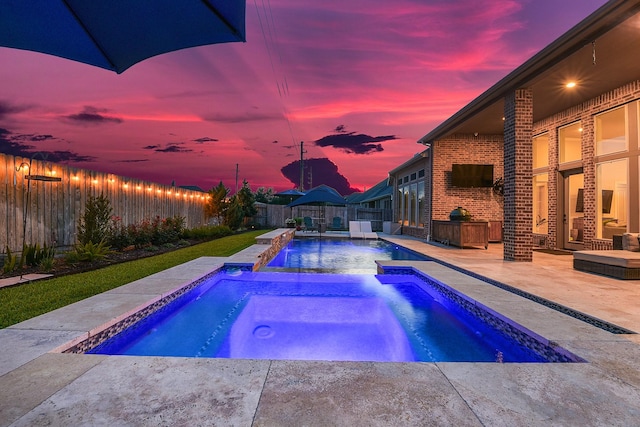 27511 Becketts Knoll Ct, Katy, TX 77494 - pool at dusk with an in-ground hot tub, a patio, and a fenced backyard