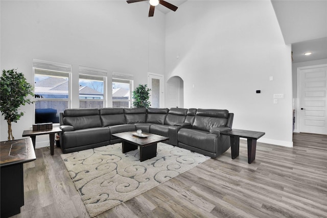 11930 Mccallister Run Dr, Humble, TX 77346 - living area featuring a towering ceiling, ceiling fan, arched walkways, wood finished floors, and baseboards