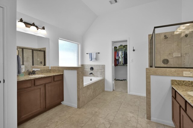 16923 Fondness Park Dr, Spring, TX 77379 - bathroom with lofted ceiling, two vanities, a shower stall, a walk in closet, and a bath