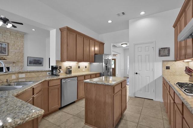 16923 Fondness Park Dr, Spring, TX 77379 - kitchen with appliances with stainless steel finishes, a sink, ceiling fan, backsplash, and light stone countertops