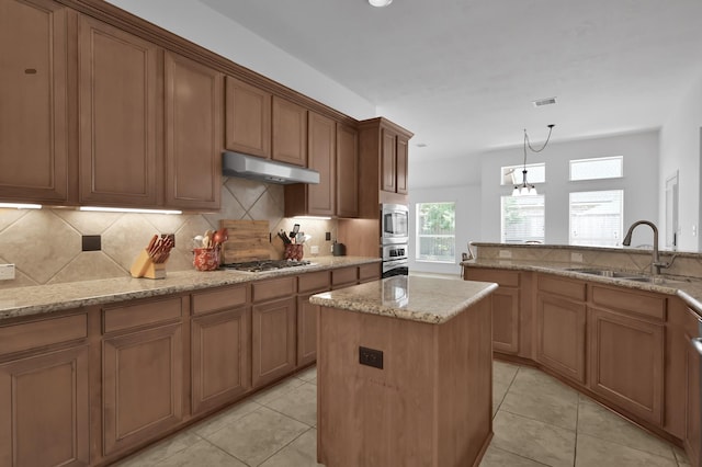 16923 Fondness Park Dr, Spring, TX 77379 - kitchen featuring appliances with stainless steel finishes, under cabinet range hood, a sink, and light tile patterned floors