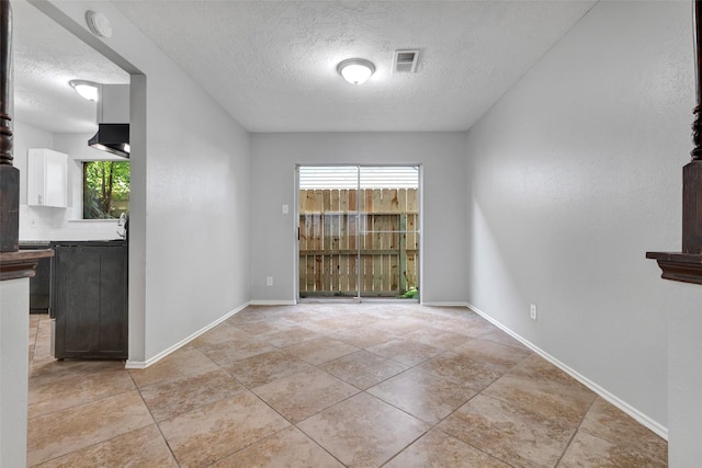 1535 Carbonear Dr, Channelview, TX 77530 - unfurnished dining area featuring a textured ceiling, light tile patterned floors, and baseboards