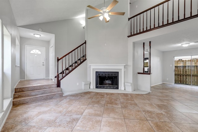 1535 Carbonear Dr, Channelview, TX 77530 - unfurnished living room featuring a ceiling fan, a high ceiling, stairs, a fireplace, and tile patterned flooring