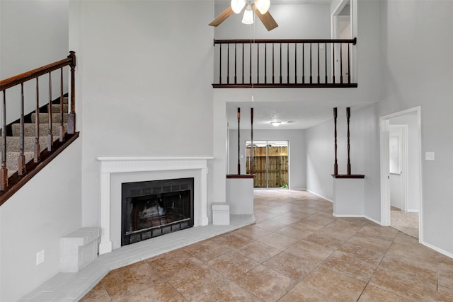 1535 Carbonear Dr, Channelview, TX 77530 - unfurnished living room with a high ceiling, ceiling fan, a fireplace with raised hearth, stairway, and baseboards