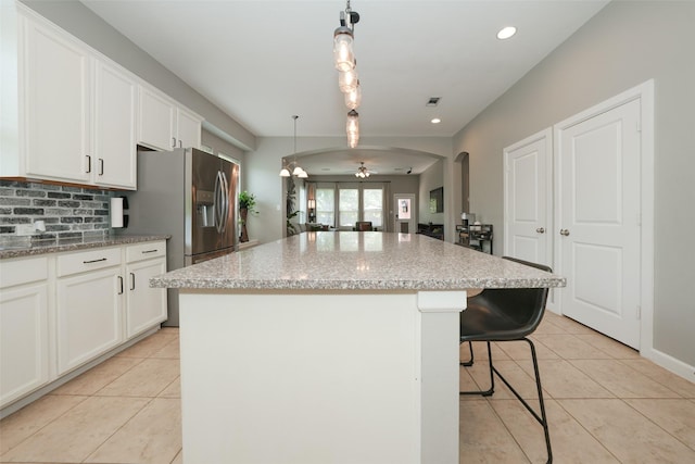 16826 Paynes Creek Dr, Cypress, TX 77433 - kitchen featuring light tile patterned floors, tasteful backsplash, a breakfast bar, a kitchen island, and recessed lighting